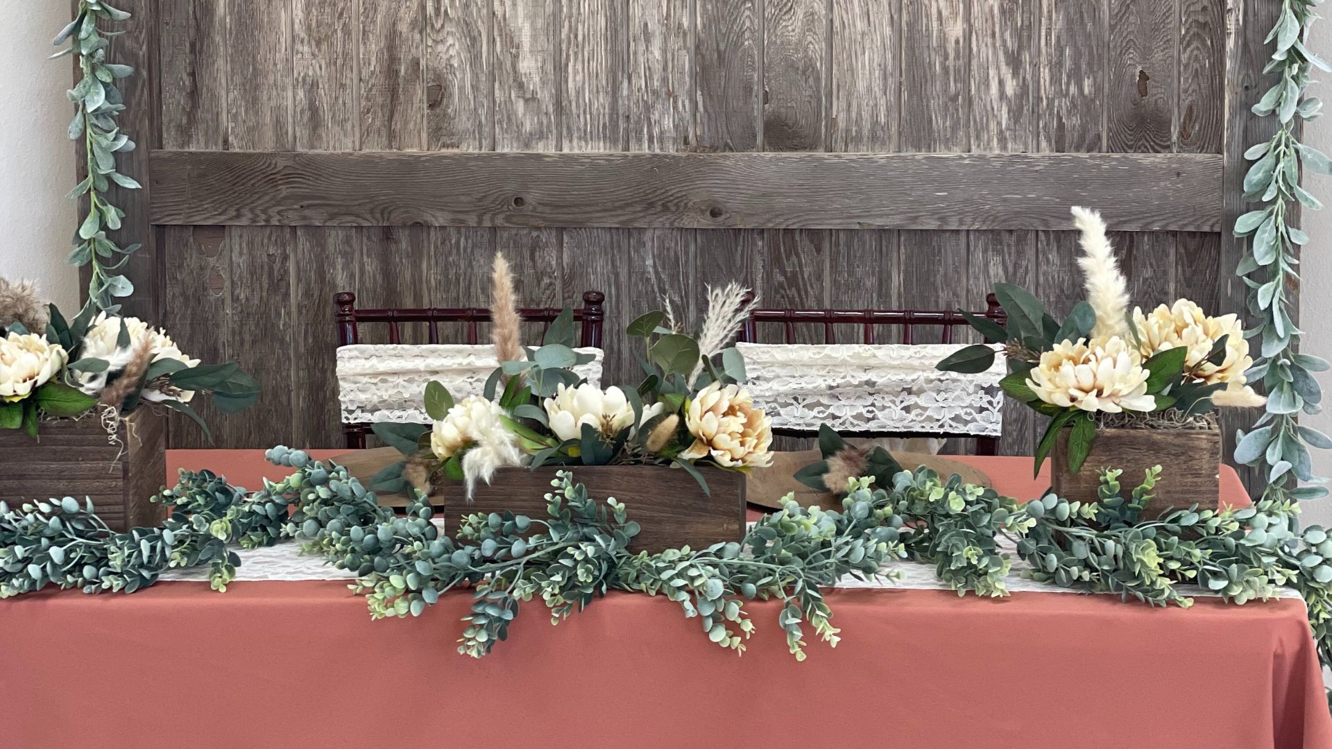 terracotta wedding reception sweetheart table with eucalyptus and pampas grass