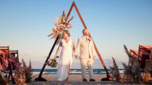 boho chic beach wedding with triangle arch and pampas grass