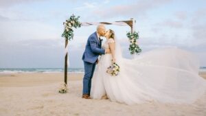 beach wedding with bride and groom and arch