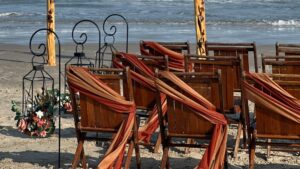 burnt orange and burgundy beach wedding arch and chairs fall